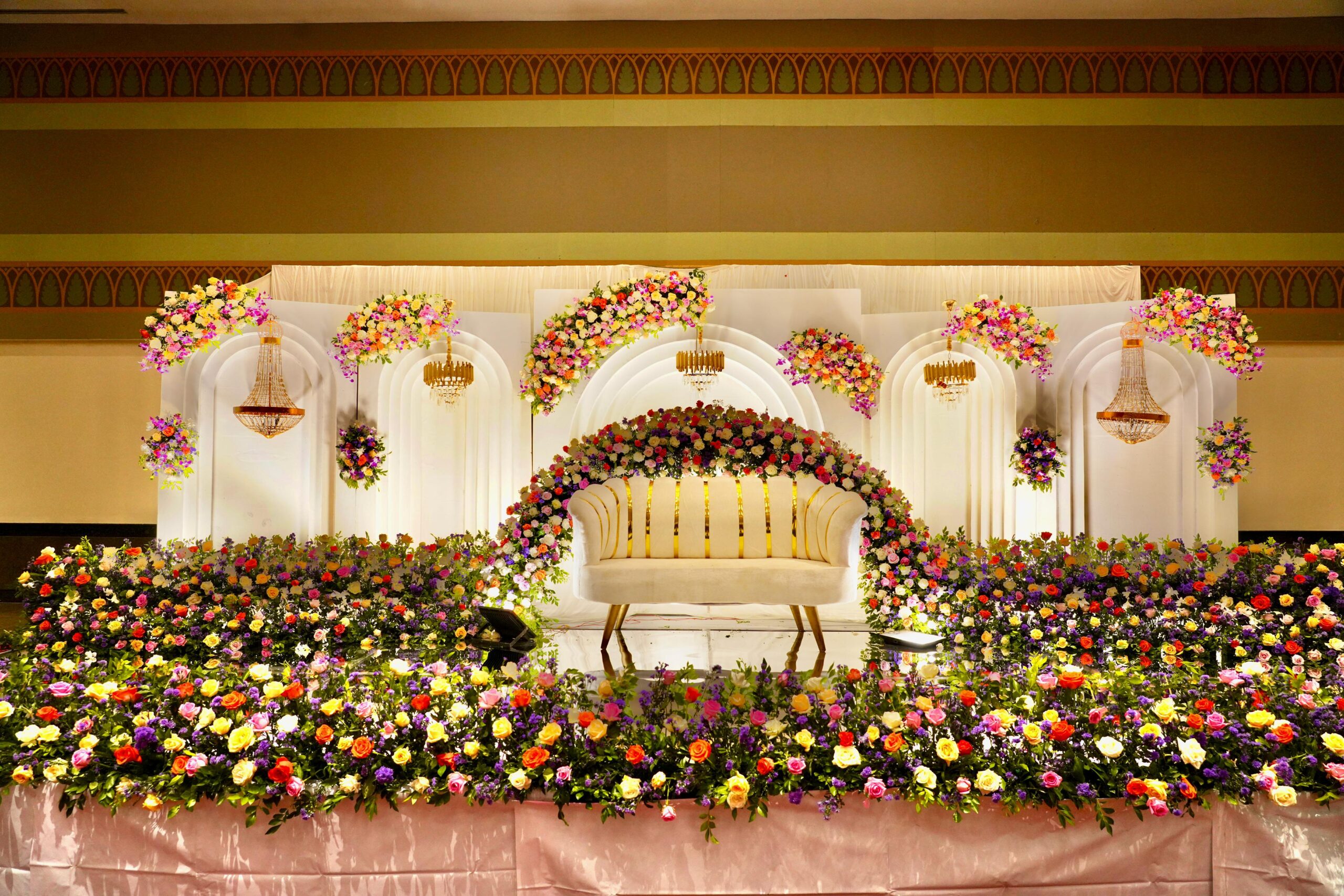 "Premium event stage with floral arrangements and lighting by VREvents"